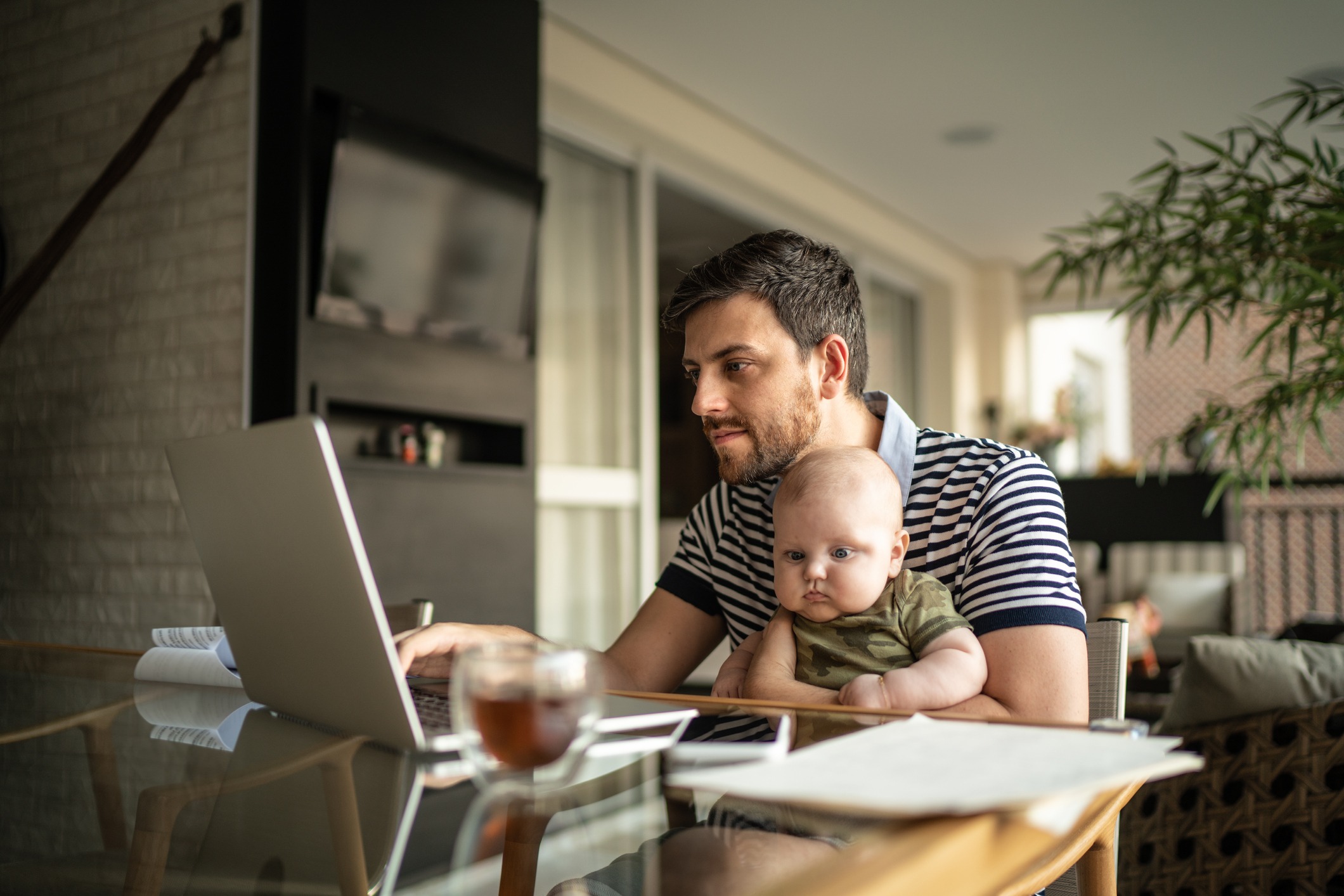 Man and a baby working on a laptop